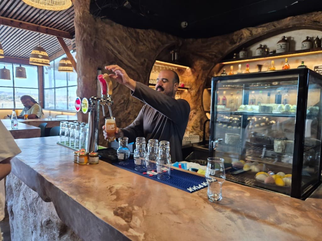 Bartender pouring a drink from the tap at the bar counter
