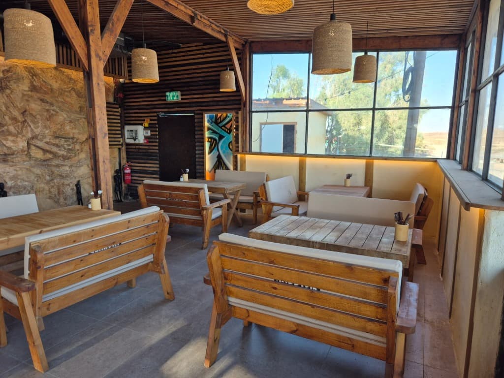 Dining area with wooden tables, windows and warm lighting